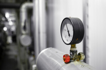 Close up view of pressure gauge on pipeline in heating plant.