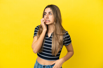 Young caucasian woman isolated on yellow background is a little bit nervous