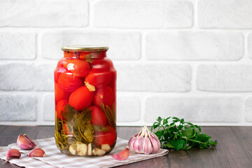 Pickled tomatoes in a glass jar. Homemade.