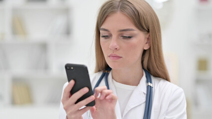 Portrait of Focused Young Doctor using Smartphone