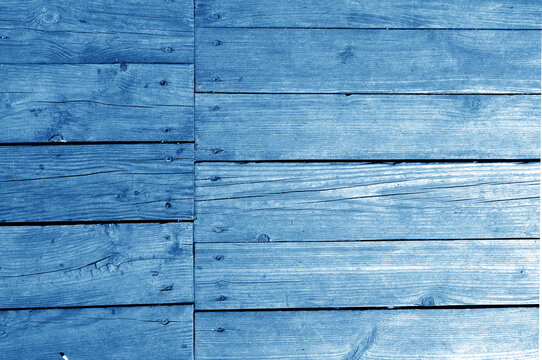 Wall made of uncutted weathered wood boards in navy blue tone.