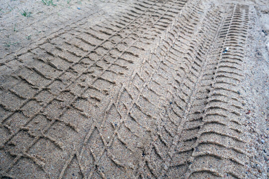 Tyre tracks on sandy dirty road.