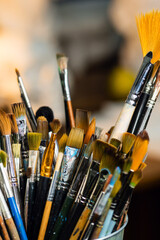 Set Collection Art Paint Brushes In Cup On Artist's Desktop. Artistic Equipment In Studio