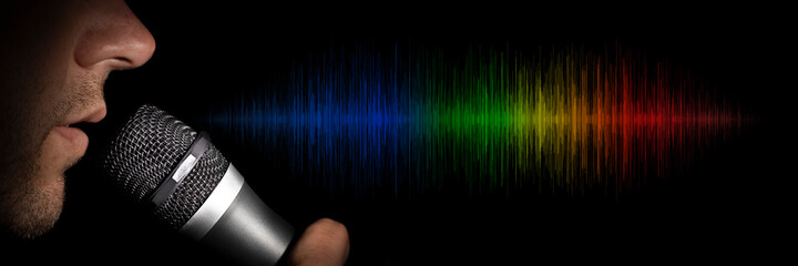 a man holding a microphone on a black background