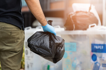 The young man separated the dangerous waste into a large black bag and put it in the trash. The...