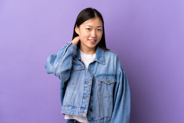 Young Chinese girl over isolated purple background laughing