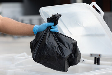 The young man separated the dangerous waste into a large black bag and put it in the trash. The...