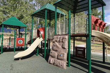 Playground Slide with 4 Chutes and A Climbing Wall Trees in Background