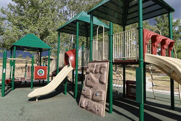 Playground Slide with 4 Chutes and A Climbing Wall Trees in Background