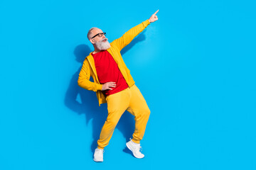 Full size profile side photo of handsome funky funny man dancing point finger copyspace isolated on blue color background