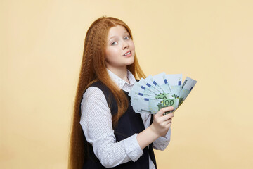 attractive red-haired girl holds 100 euro banknotes in her hands