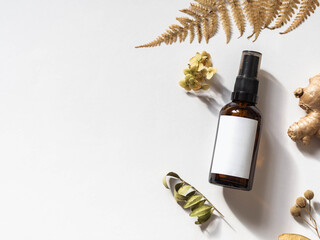 Organic natural product - oils, various dry plants and glass bottle mockup on white background