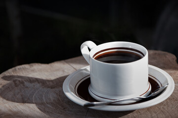 morning black coffee on wooden table in sunshine