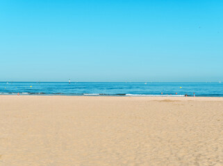 Fototapeta na wymiar Plage de Normandie, mer bleue et ciel bleu avec la plage brune et claire