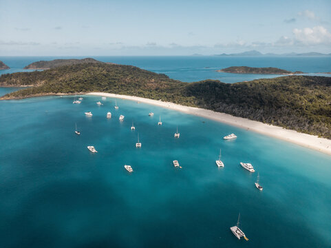 Aerial view of catamarans and yachts anchored along South Whitehaven beach, Queensland, Australia.