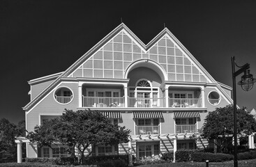 Detached two-storied house facade with siding against sky