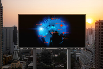 Glowing hologram of Earth planet map on billboard over aerial panoramic cityscape of Bangkok at sunset. The concept of international business in Southeast Asia.