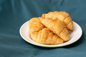 Croissants on a piece of white cloth on the blue.