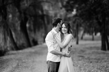 a guy and a girl are walking along the banks of a wild river overgrow