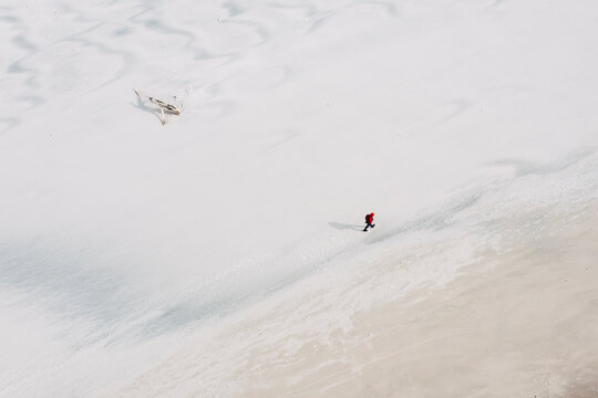Aerial view of person walking alone in wild, Baltic sea coast beach on a sunny spring day near Klaipeda, Lithuania.