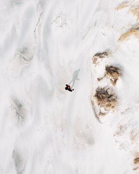 Aerial view of man standing on white sand Baltic sea beach near Klaipeda, Lithuania.
