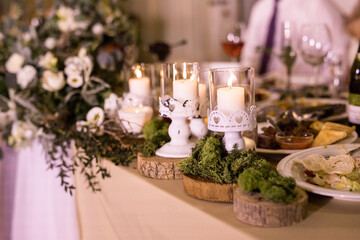 Obraz na płótnie Canvas The presidium with floral arrangement with fresh white rose, wooden small circles with moss and fashion white candles