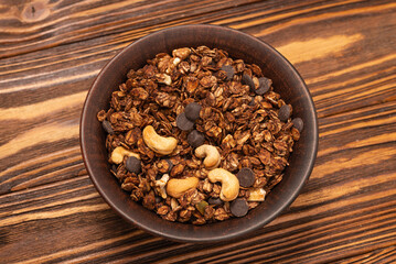 Chocolate granola cereal with nuts in a bowl.