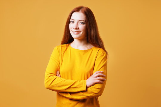 Happy Confident Young Woman With Her Arms Folded Smiling Into Camera