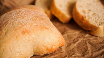 Ciabatta slices on craft paper. Fresh delicious pastries. Fresh homemade bread.