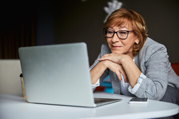 Mature attractive woman watching online business conference