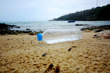 Fototapeta na wymiar A plastic bottle floating in the sea in a beach with dirty coast