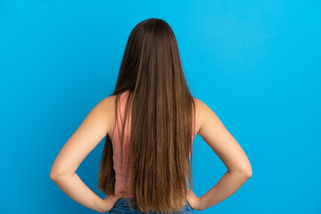Naklejka premium Young caucasian woman isolated on blue background in back position