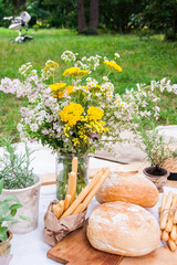 Wheat bread and Grissini, among the flowers on a picnic