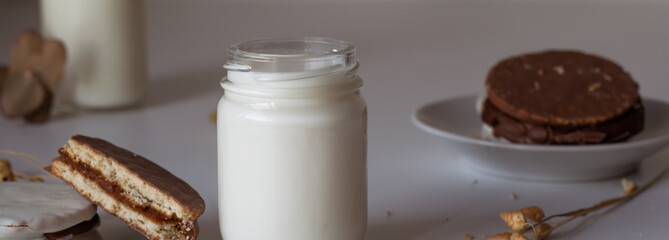 glass of milk with dulce de leche alfajores covered with black and white chocolate, typical food of Argentina