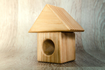 Obraz na płótnie Canvas Small house figurine made of wood, real estate concept.