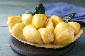 Fresh exotic jackfruit bulbs on light blue wooden table, closeup