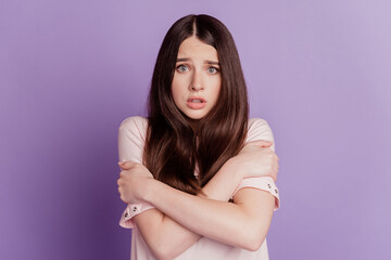 Portrait of deserate unhappy woman hands embrace shoulders freeze isolated on purple background