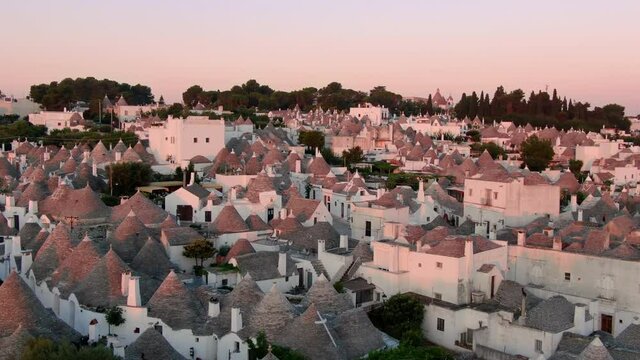trulli of alberobello aerial shot drone flying forward at dawn,puglia famous travel destination at sunrise