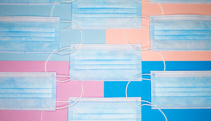 Coronavirus protection. Blue antiviral medical face masks. Surgical protective masks on blue and pink background.