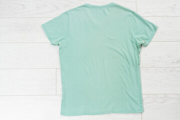 Green t-shirt close up top view on wooden background, t shirt copy space