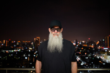 Portrait of mature man with gray beard outdoors at night
