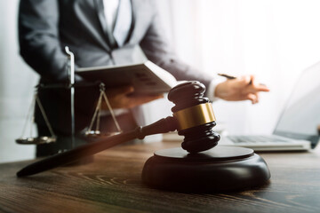 Justice and law concept.Male judge in a courtroom with the gavel, working with, computer and...