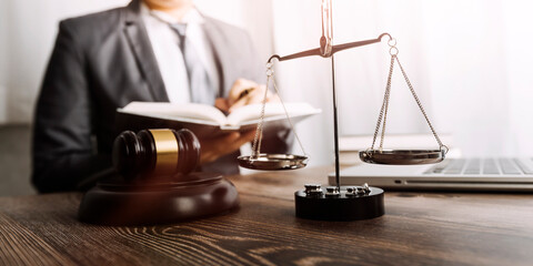 Justice and law concept.Male judge in a courtroom with the gavel, working with, computer and docking keyboard, eyeglasses, on table in morning light