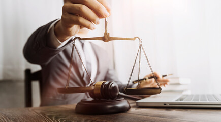 Justice and law concept.Male judge in a courtroom with the gavel, working with, computer and...
