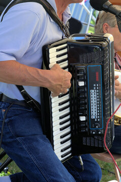 Accordian player's right hand on the instrument keyboard.