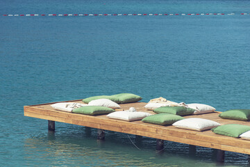 Wooden Pier with Big Pillows in the Sea .Summer Holiday