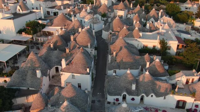 Italian landmark trulli of alberobello aerial view drone top down shot at sunrise,famous travel destination puglia
