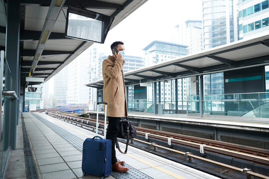 UK, London, Man waiting at train station platform