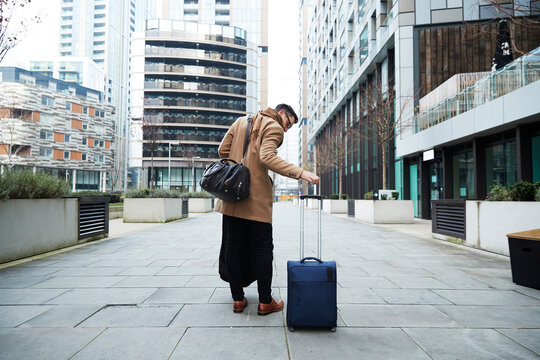 UK, London, Man pulling suitcase