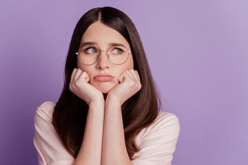 Portrait of sad unhappy woman look empty space fists face isolated on purple background